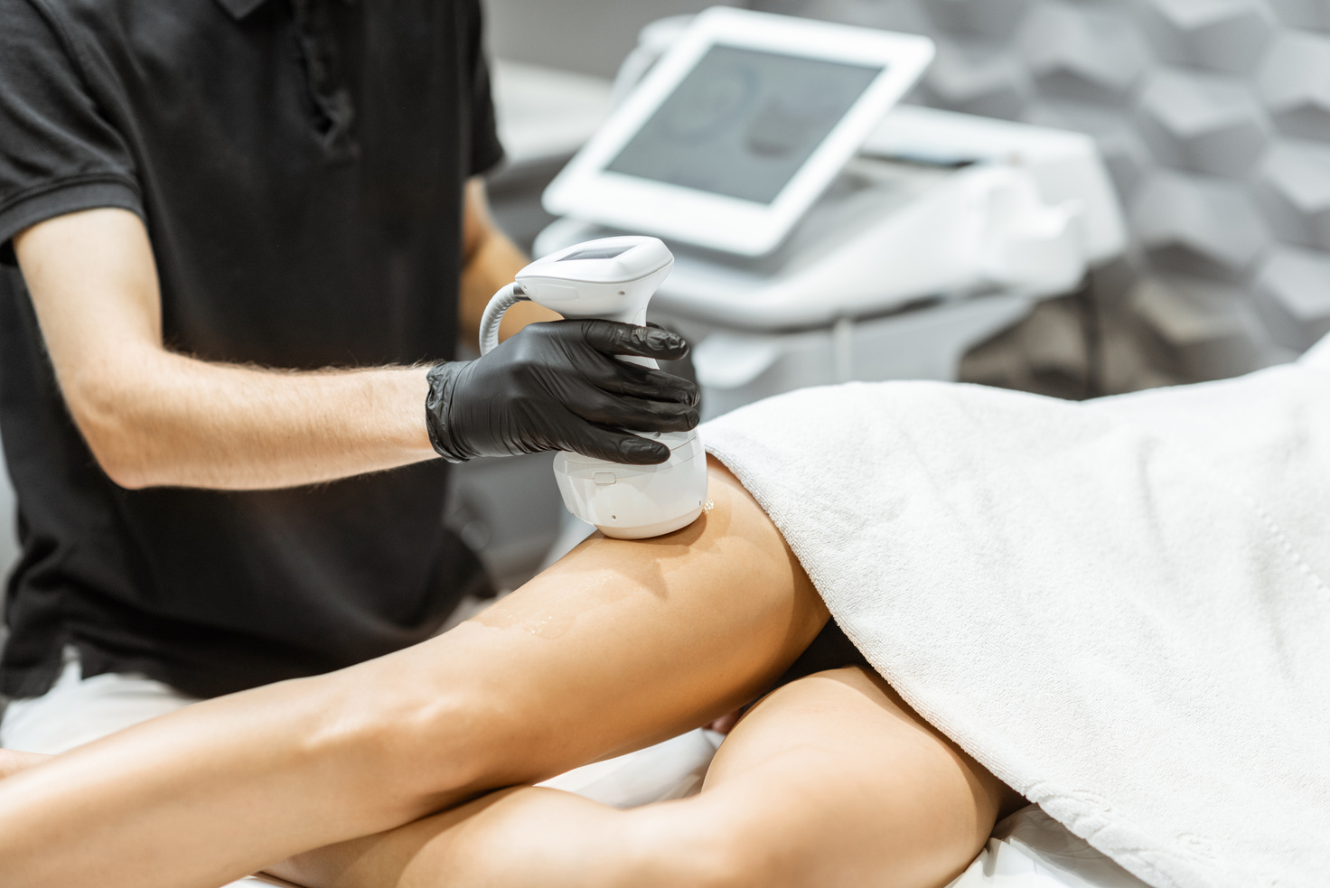 Technician Holding a Sculpting Machine Over a Leg 