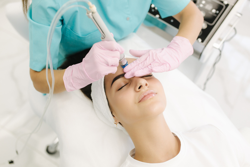 Professional Female Cosmetologist Doing Hydrafacial Procedure in Cosmetology Clinic. Doctor Use Hydra Vacuum Cleaner. Rejuvenation and Hydratation. Cosmetology